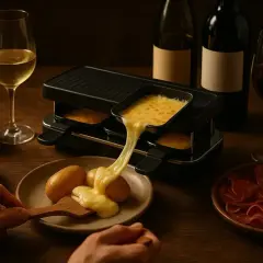 Raclette savoyarde fondante avec vin blanc de Savoie. Fromage coulant sur pommes de terre, accompagné de charcuterie et cornichons.