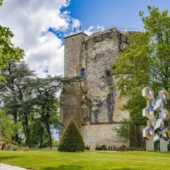La tour des fiefs Sancerre, vestige historique, se dresse fièrement dans un parc verdoyant, orné d'une sculpture moderne et d'un food truck.