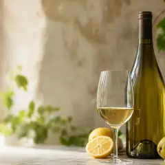 Verre de vin blanc, citron, poire et raisins, évoquant les meilleurs sauvignon blanc.