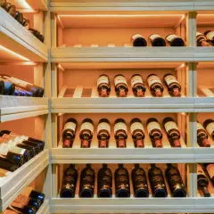 Une cave à vin en bois avec de nombreuses bouteilles. Un guide millésime vin idéal pour choisir la meilleure cuvée.