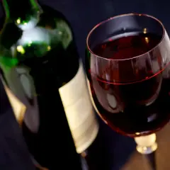 Bouteille de vin rouge et verre rempli. Attention, un vin trop vieux peut présenter un danger.