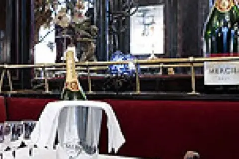 Bouteille de champagne Mercier dans un seau à glace, prête à être servie. Les verres à pied sont disposés sur la table. Avis : une belle expérience.