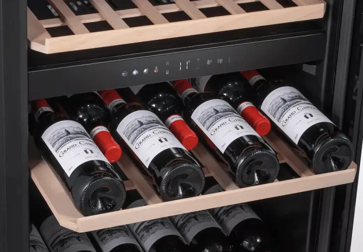 Une cave à vin bien remplie de bouteilles de vin rouge. Idéal pour savoir comment choisir votre prochaine bouteille.
