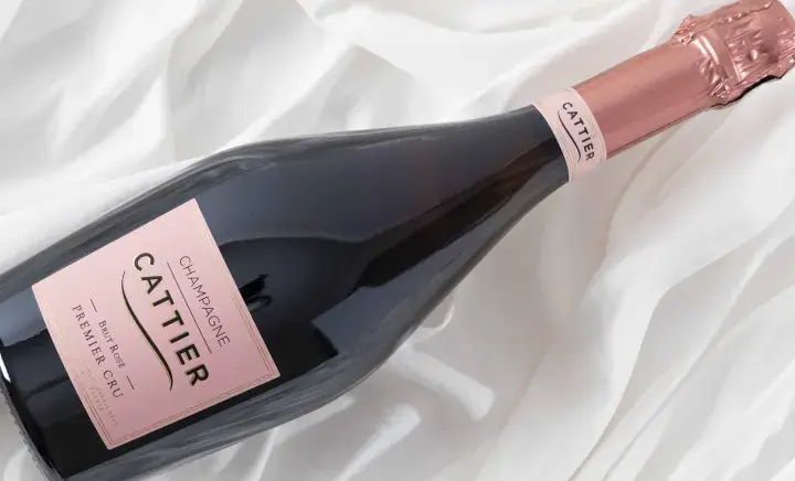 Bouteille de champagne Cattier Brut Rosé Premier Cru sur fond blanc plissé. Un avis sur ce champagne est très attendu.