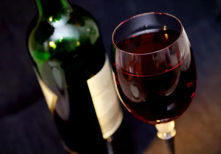 Bouteille de vin rouge et verre rempli. Attention, un vin trop vieux peut présenter un danger.