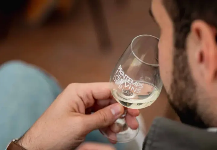 Un homme déguste un verre de vin blanc, logo "Printemps des Vins de Blaye" visible.