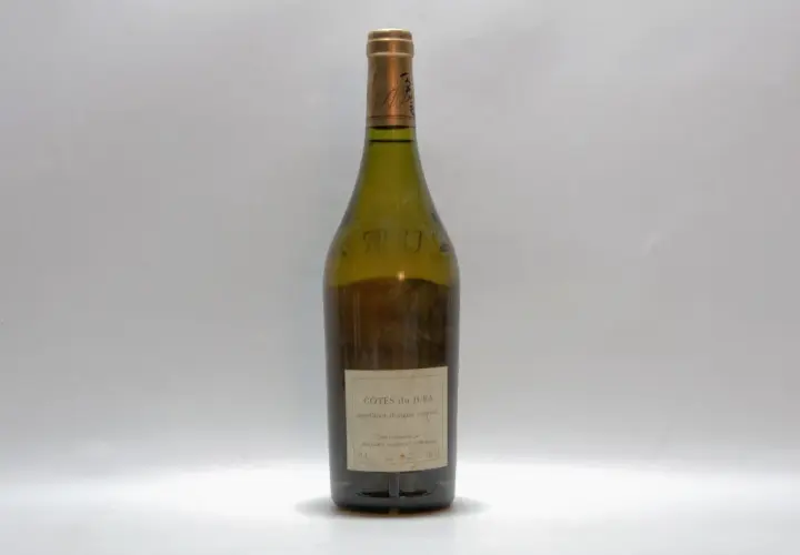 Bouteille de vin blanc des Côtes du Jura, millésime non visible, sur fond blanc.