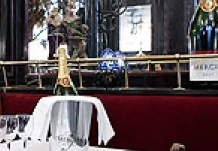 Bouteille de champagne Mercier dans un seau à glace, prête à être servie. Les verres à pied sont disposés sur la table. Avis : une belle expérience.