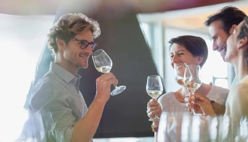 Un homme et une femme dégustent du vin blanc, un moment convivial pour ce guide du vin.
