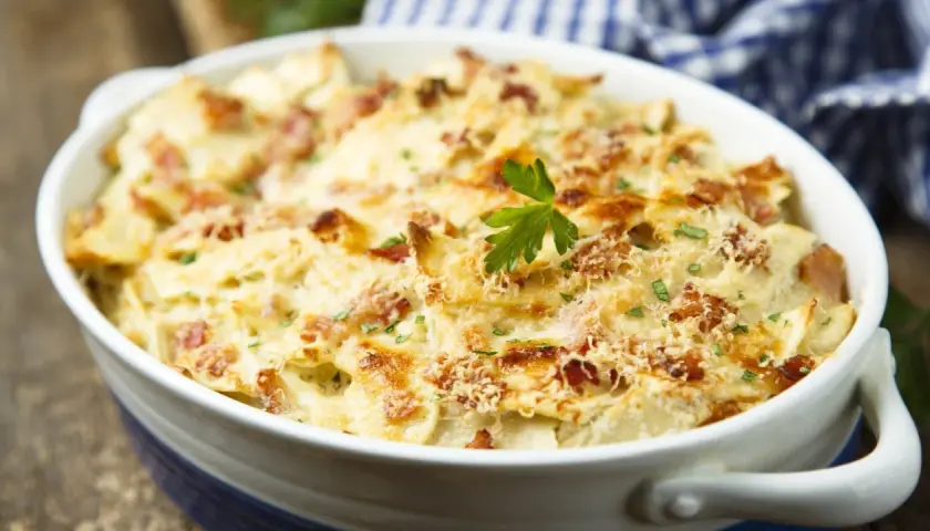 Gratin dauphinois crémeux avec lardons, garni de persil. Un plat réconfortant, idéal pour savoir quel vin avec quel plat.