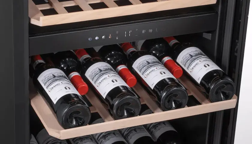 Une cave à vin bien remplie de bouteilles de vin rouge. Idéal pour savoir comment choisir votre prochaine bouteille.