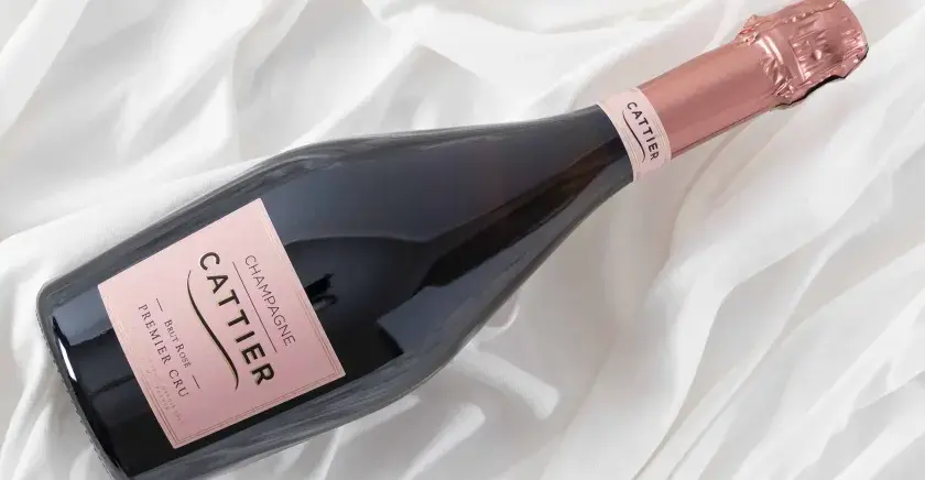 Bouteille de champagne Cattier Brut Rosé Premier Cru sur fond blanc plissé. Un avis sur ce champagne est très attendu.