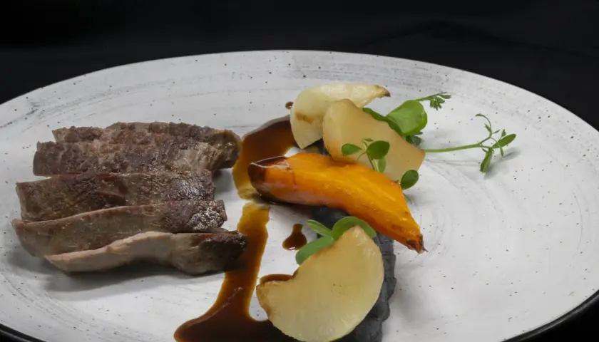 Tranches de viande savoureuses, carotte glacée, pommes de terre et sauce brune sur une assiette. Un plat qui donne envie, comme les dames de la Loire avis.