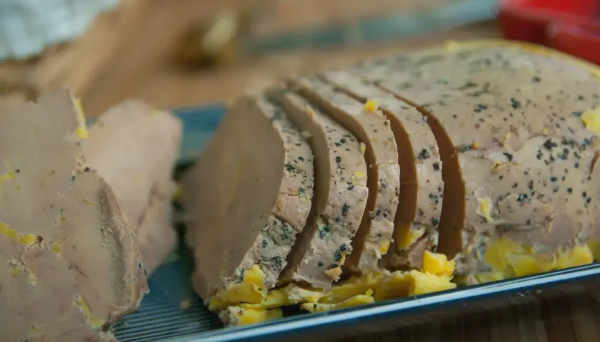 Tranches de foie gras assaisonnées de poivre noir, prêtes pour un accord mets vins parfait.