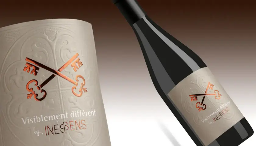 Étiquette de vin avec des clés croisées dorées et le texte "Visiblement différent by INESPENS". Un nom de cépage top 7 à découvrir.