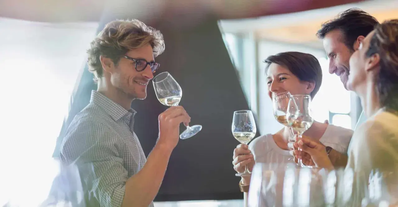 Un homme et une femme dégustent du vin blanc, un moment convivial pour ce guide du vin.