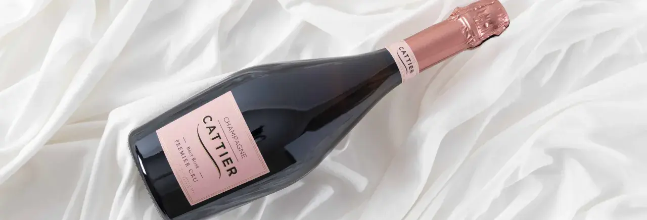 Bouteille de champagne Cattier Brut Rosé Premier Cru sur fond blanc plissé. Un avis sur ce champagne est très attendu.