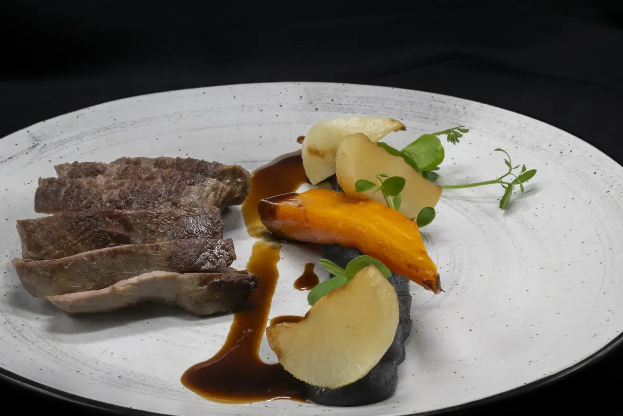 Tranches de viande savoureuses, carotte glacée, pommes de terre et sauce brune sur une assiette. Un plat qui donne envie, comme les dames de la Loire avis.