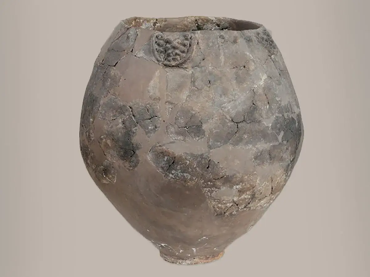 Vase antique craquelé, témoin du berceau du vin. Son argile patinée raconte des histoires de fermentation et de partage.