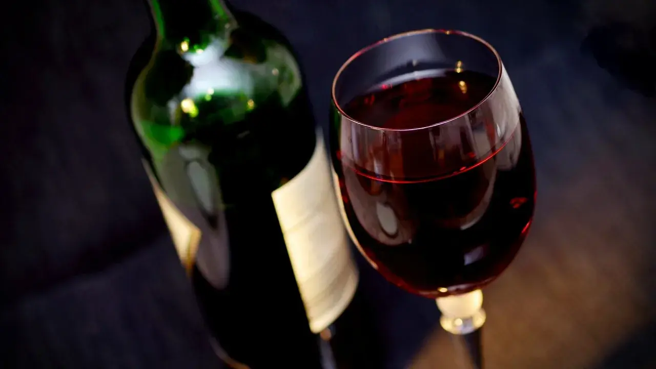 Bouteille de vin rouge et verre rempli. Attention, un vin trop vieux peut présenter un danger.