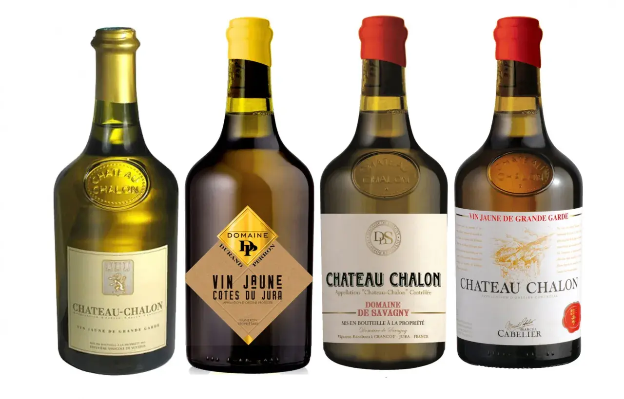 Quatre bouteilles de vin jaune du Jura, dont Château-Chalon et Côtes du Jura, présentées sur fond blanc.