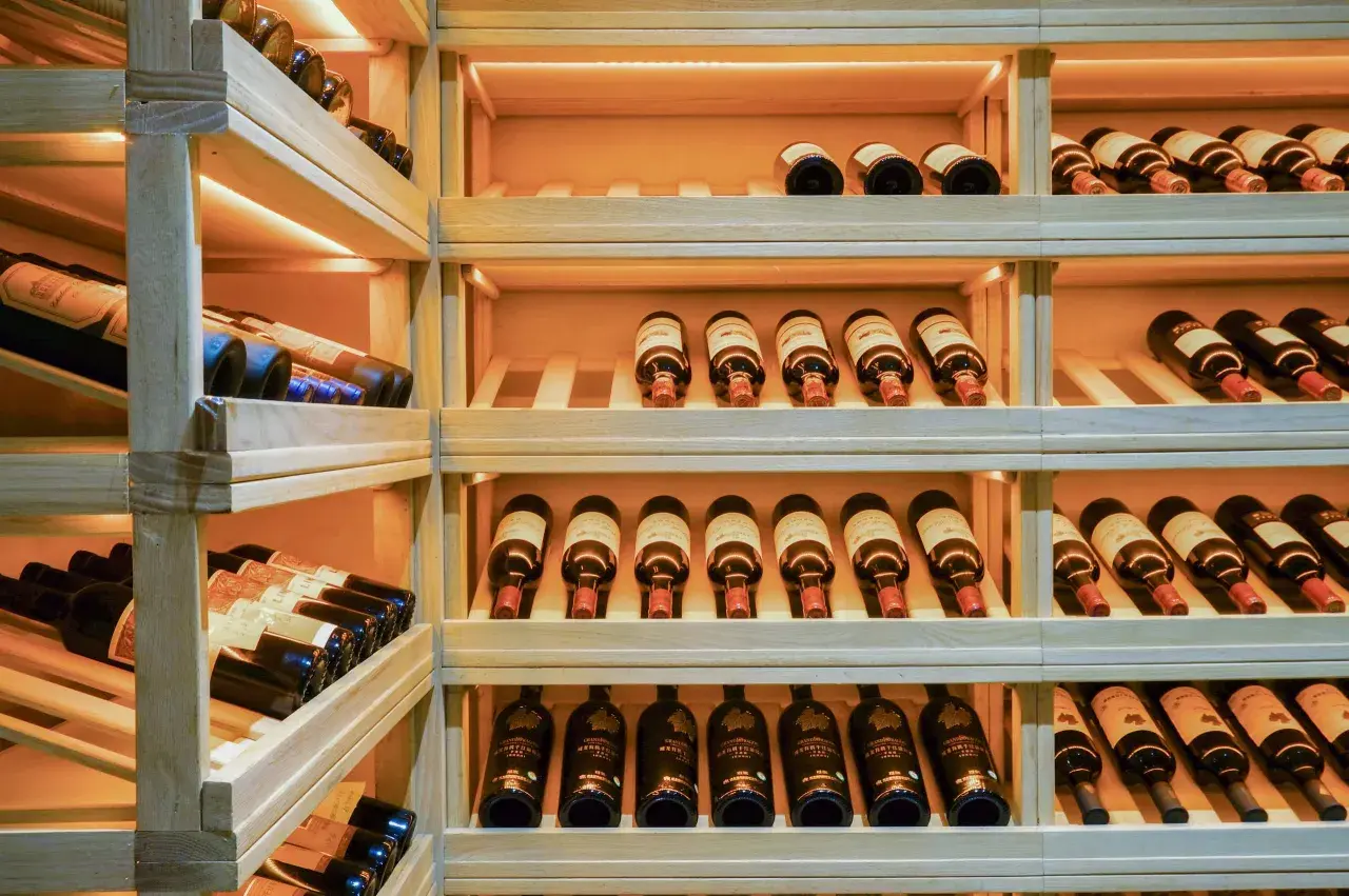 Étagères en bois remplies de bouteilles de vin, parfait pour faire sa cave à vin.