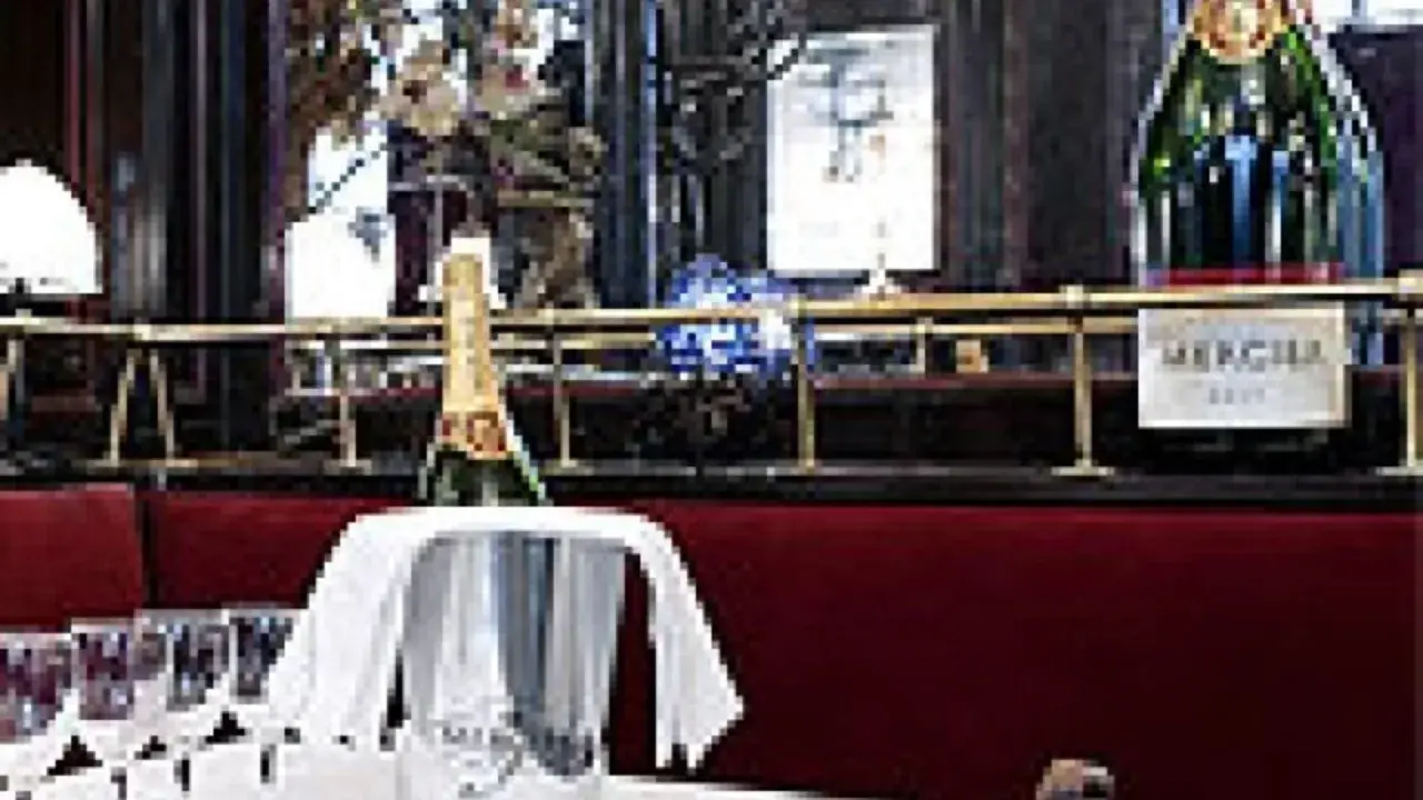 Bouteille de champagne Mercier dans un seau à glace, prête à être servie. Les verres à pied sont disposés sur la table. Avis : une belle expérience.