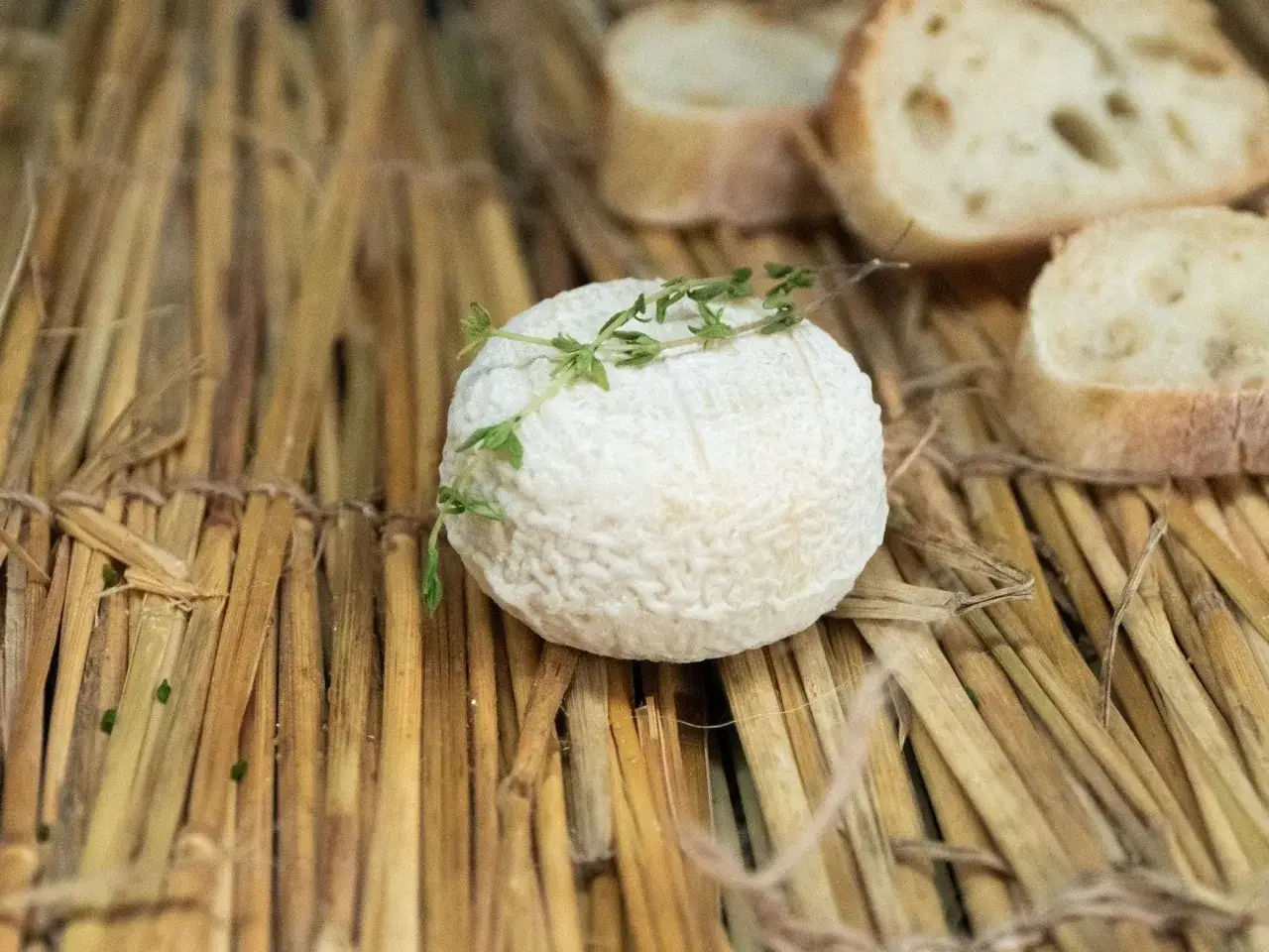 Un fromage de chèvre frais garni de thym, prêt à être dégusté. Parfait pour savoir que manger avec un pouilly fumé, accompagné de fines tranches de pain.