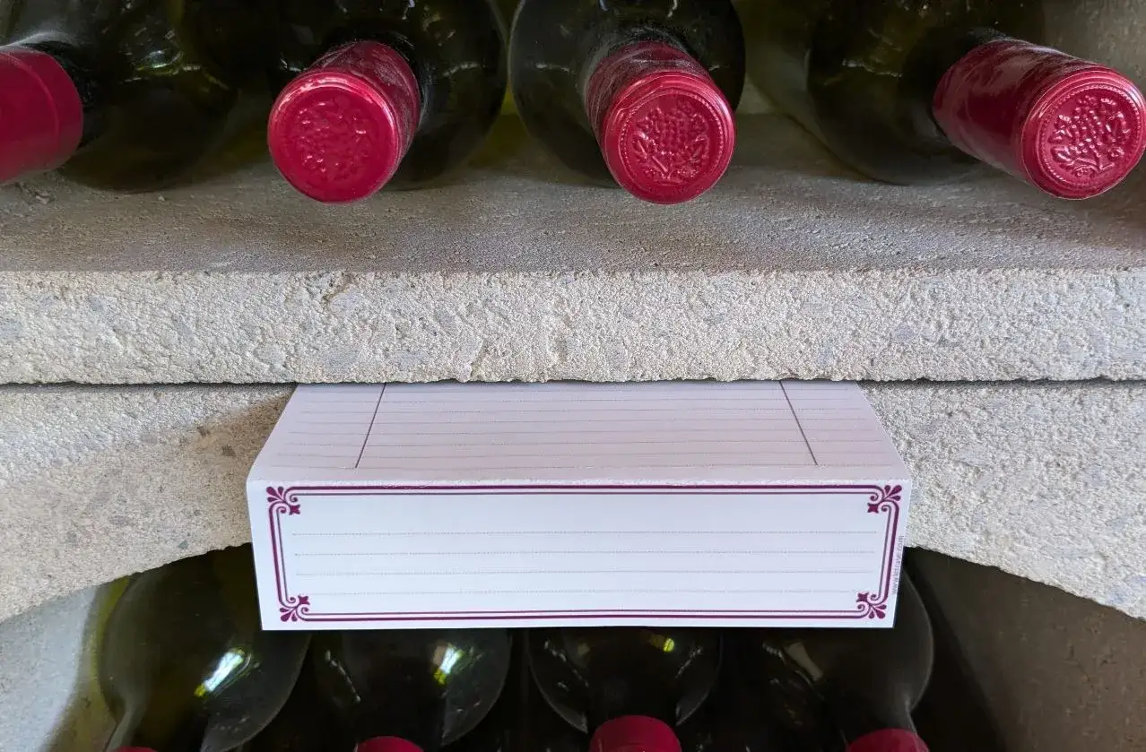 Bouteilles de vin dans une cave, avec une étiquette pour faire sa cave à vin.