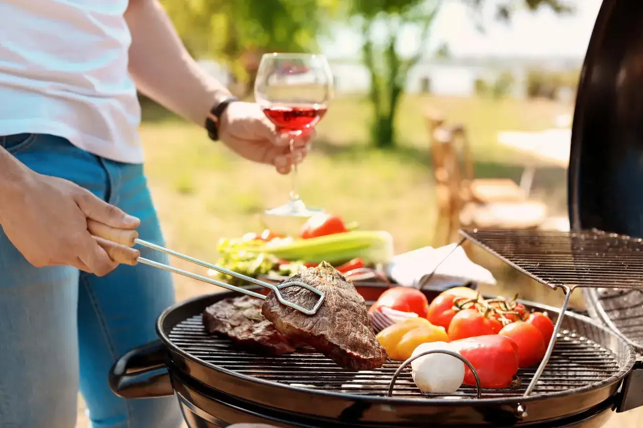 Un verre de ros&eacute;, des steaks et des l&eacute;gumes sur le grill. Le parfait quel ros&eacute; pour barbecue, une ambiance estivale.